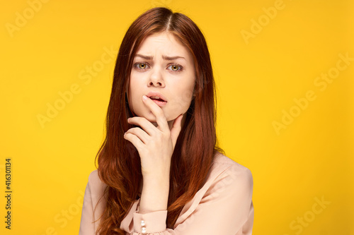 cheerful attractive woman posing hand near face yellow background
