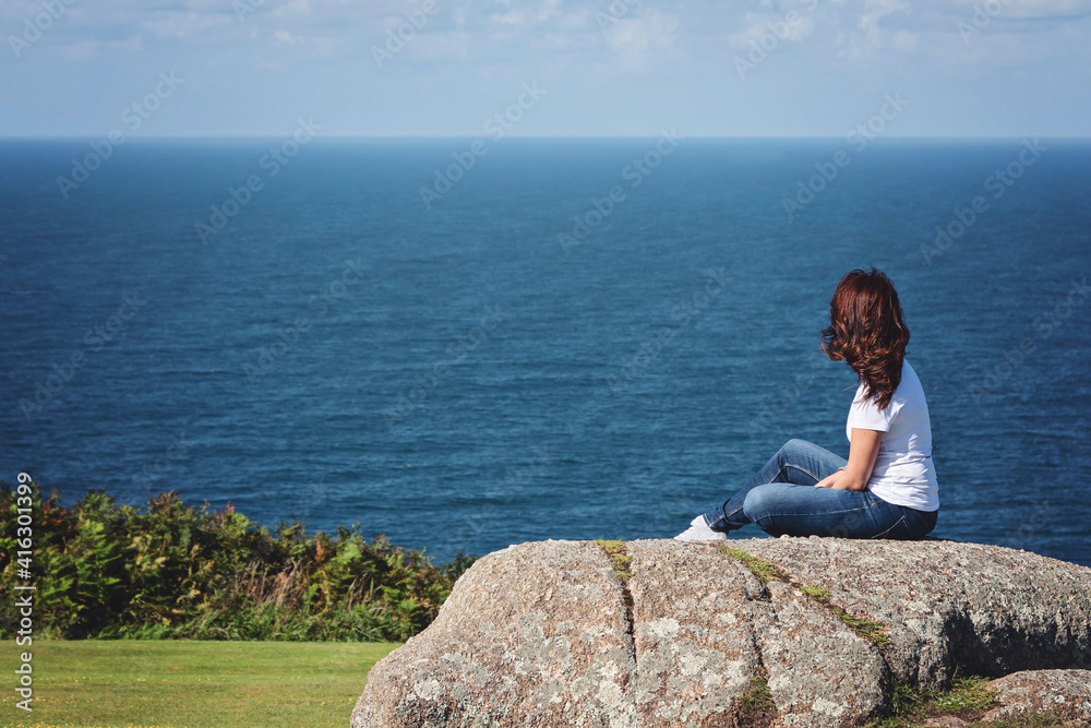 young woman back view in front of a sea landscape young woman back view in front of a sea landscape