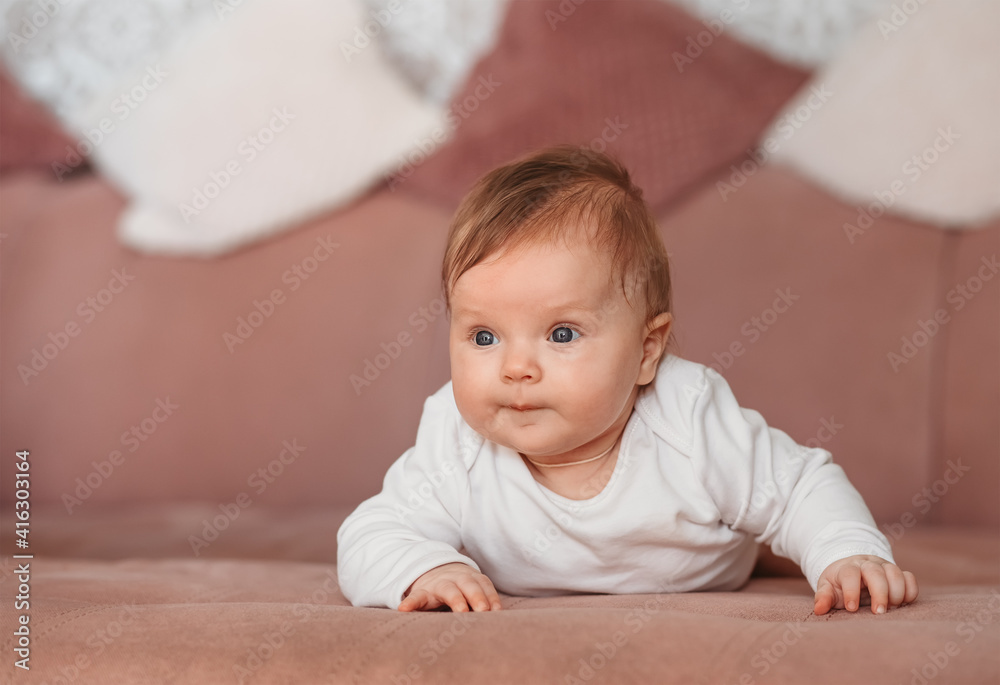 Beautiful newborn girl lies on her tummy on the bed Beautiful newborn girl lies on her tummy on the bed