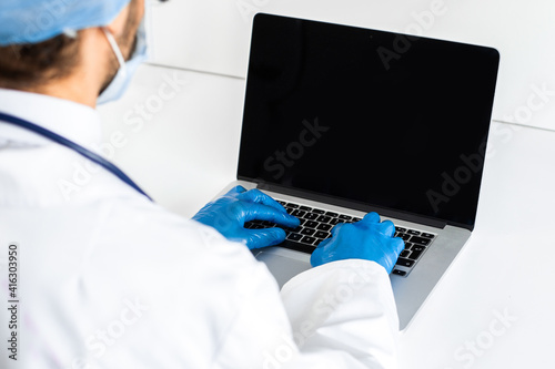 close up. doctor wear protective gloves when using the laptop .