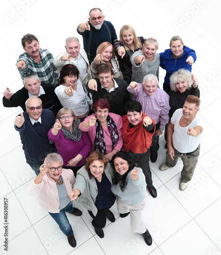 group of happy elderly people pointing at you .