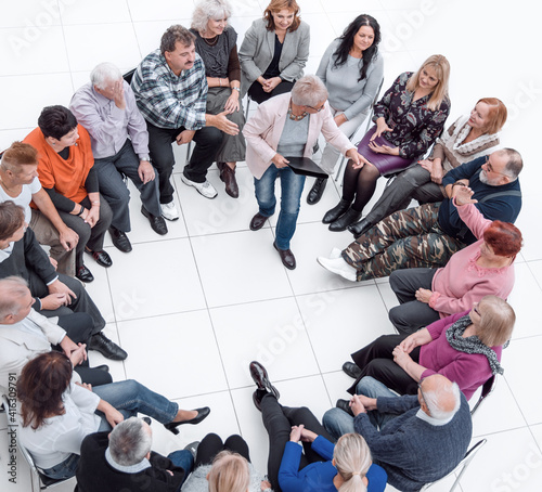 confident older woman standing in a circle of like-minded people