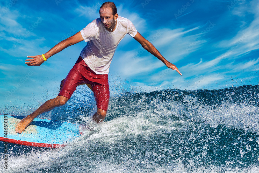 Male surfer on a blue wave at sunny day Male surfer on a blue wave at sunny day