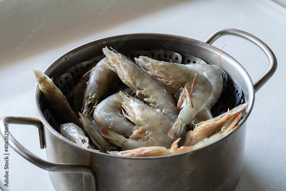 Put raw shrimp in a pot to cook. Put raw shrimp in a pot to cook.