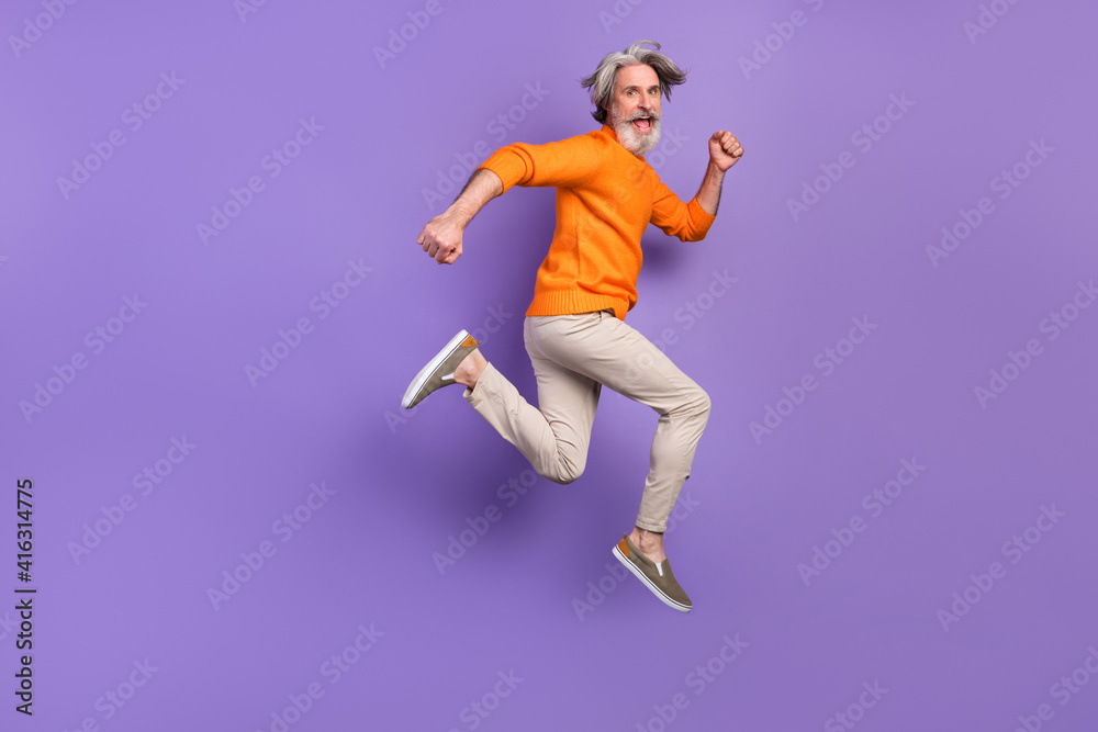 Full size profile side photo of mature man happy positive smile go walk run jump hurry sale isolated over purple color background