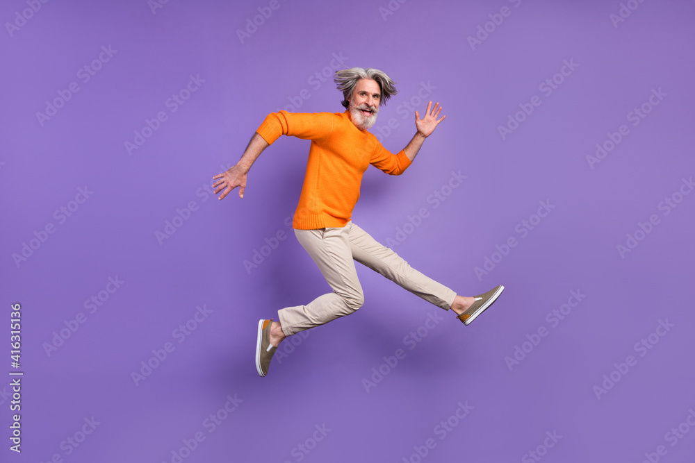 Full body profile side photo of aged man have fun jump happy positive smile isolated over purple color background