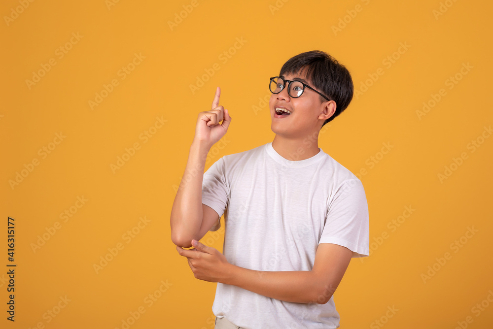 Image of a young Asian man wearing glasses, successfully seeking solutions on orange background. Image of a young Asian man wearing glasses, successfully seeking solutions on orange background.
