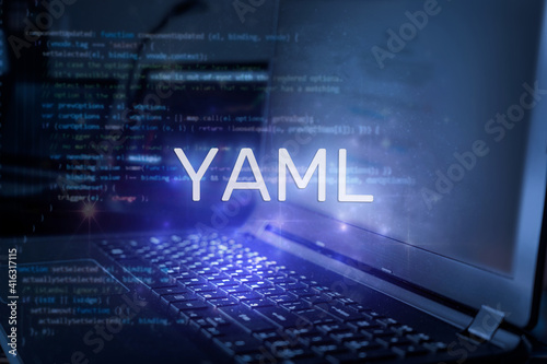 YAML inscription against laptop and code background. Technology concept. photo