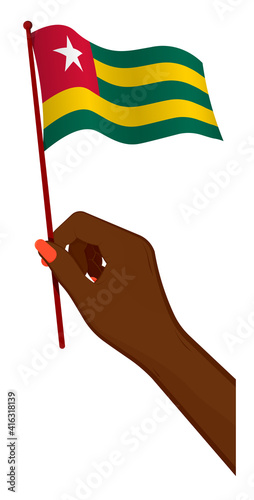 Female hand gently holds small flag of Togolese Republic. Holiday design element. Cartoon vector on white background