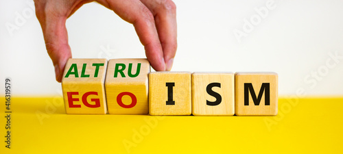 Altruism or egoism symbol. Businessman turns wooden cubes and changes the word 'egoism' to 'altruism'. Beautiful white background, copy space. Business, psychological and altruism or egoism concept. photo