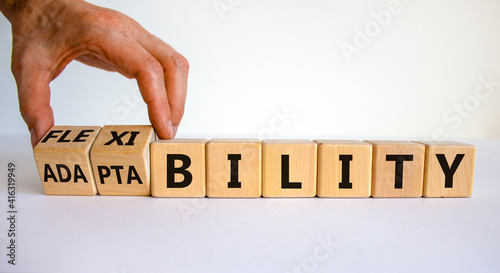 Flexibility and adaptability symbol. Businessman turns wooden cubes and changes words 'adaptability' to 'flexibility'. White background, copy space. Business, flexibility and adaptability concept. photo