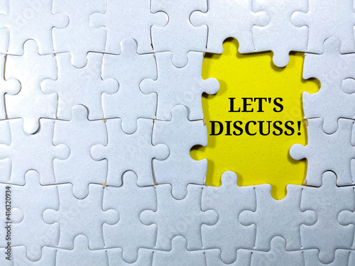 Selective focus.Word LET'S DISCUSS with jigsaw puzzle on yellow background.Business concept.