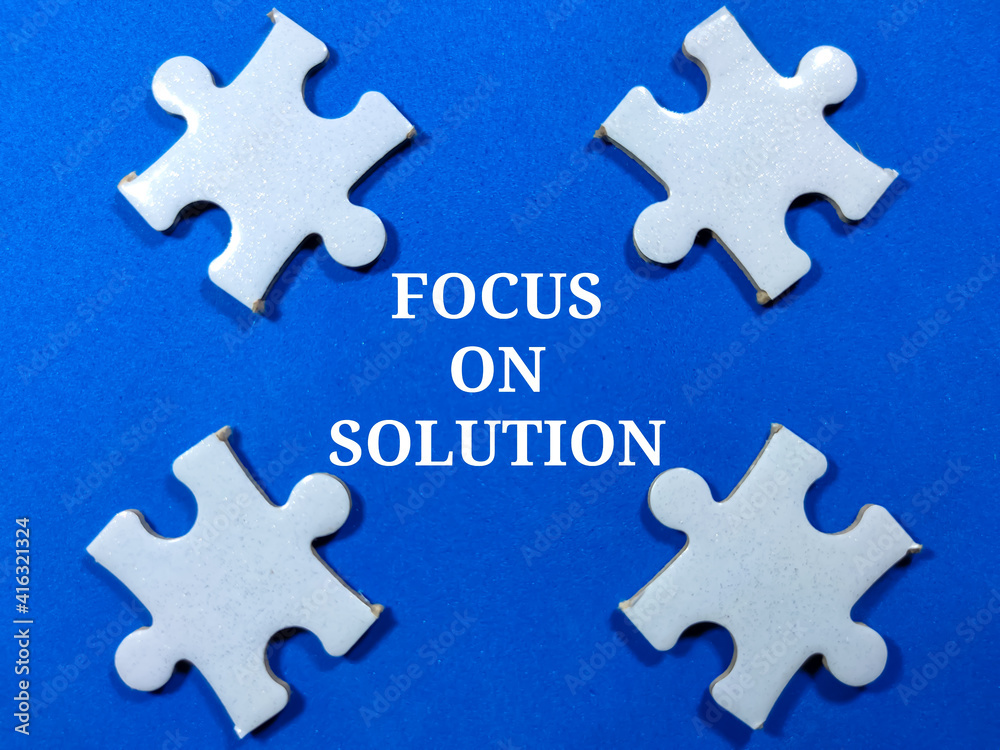 Selective focus.Word FOCUS ON SOLUTION with jigsaw puzzle on blue background.Business concept. Selective focus.Word FOCUS ON SOLUTION with jigsaw puzzle on blue background.Business concept.