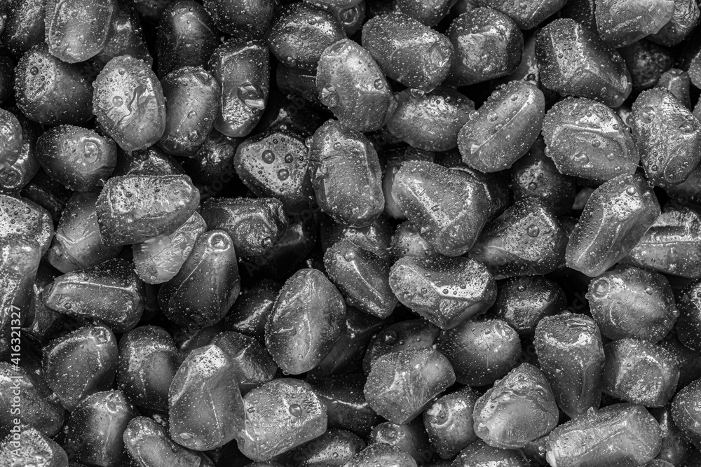 Fresh pomegranate grains with water drops. Black and white background Fresh pomegranate grains with water drops. Black and white background