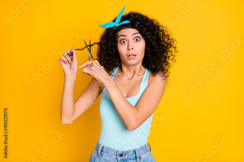 Photo of shiny shocked wavy lady dressed turquoise tank-top ready cut scissors curl isolated yellow color background