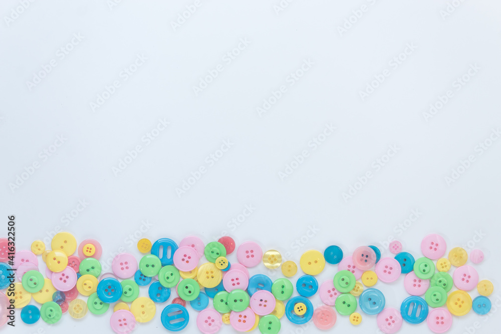 Colorful buttons on a white background. A place for text. Green, blue, yellow, pink buttons. Colorful buttons on a white background. A place for text. Green, blue, yellow, pink buttons.