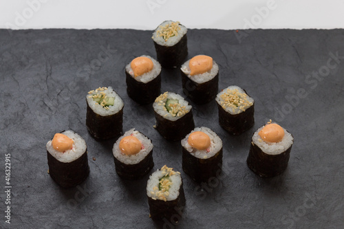 mini rolls are lined with Christmas trees. Rice, cucumber, sesame, avocado, nori. view from 45 degrees