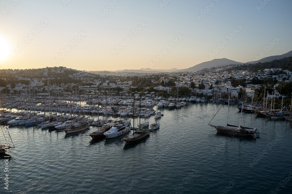 Aerial view of marina harbor in Bodrum, Turkey. Ships and yachts in the port at sunset. Summer vacation concept.