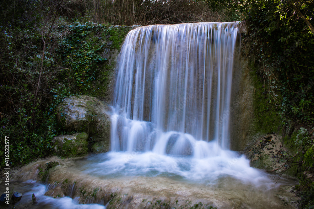 Waterfall of Quiaios in Portugal, also known as Cascata de Quiaios near Figueira da Foz, a beautiful and peaceful natural hidden spot in the woods. Long exposure photo of small cascade