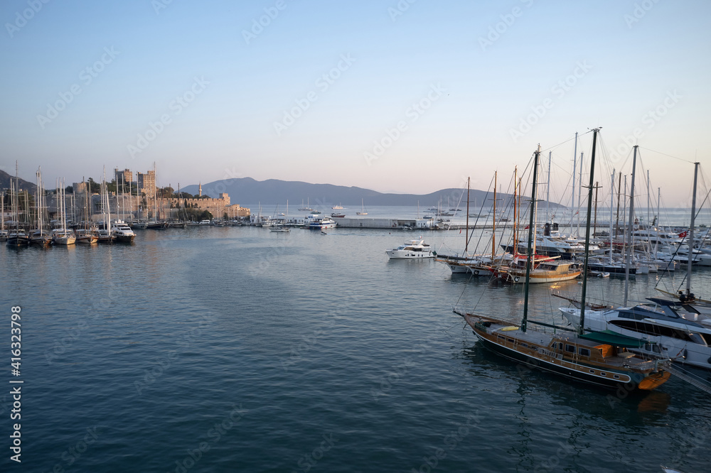Bodrum castle, mountains and sailing boats, Turkey. Harbor with boats in Aegean sea.