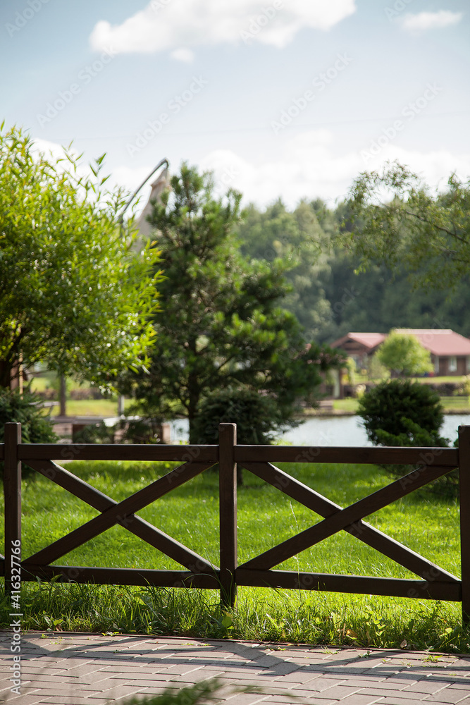 The summer country club is surrounded by a stylish wooden fence.