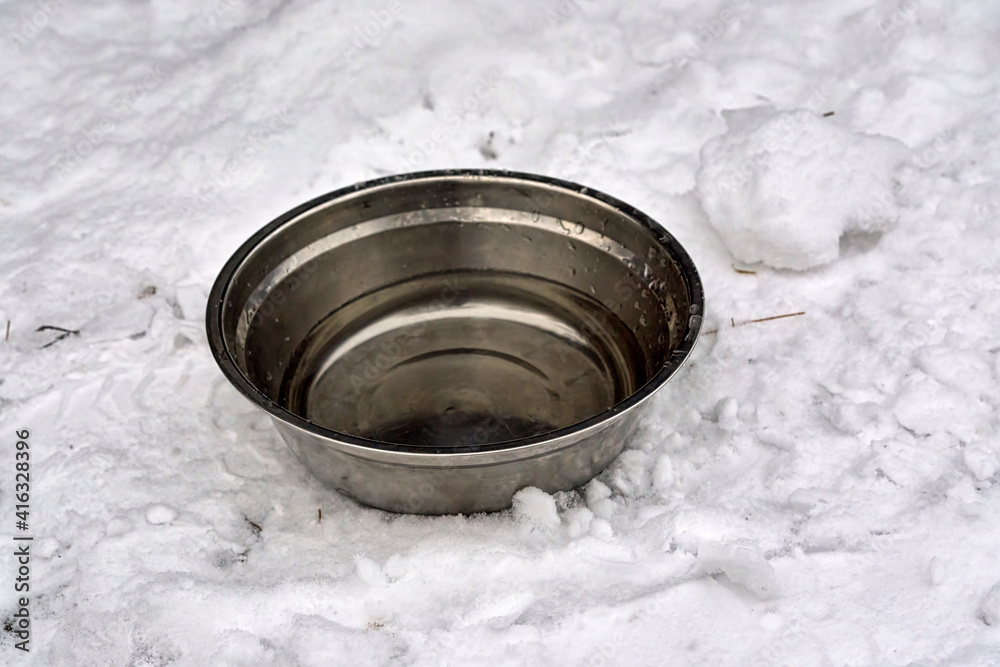 iron bowl with water to drink to animals in the snow iron bowl with water to drink to animals in the snow