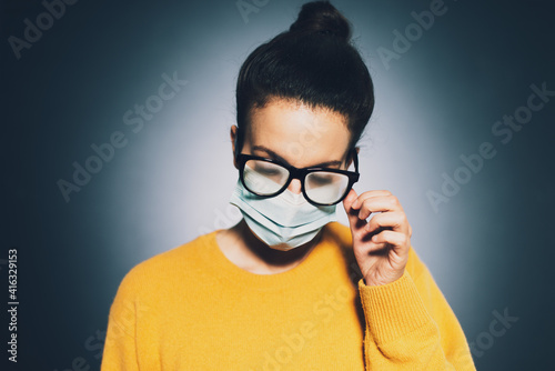 Female with foggy glasses caused by wearing medical face mask