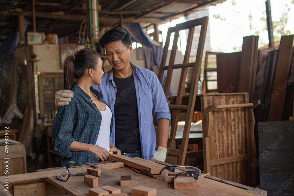 Two asian carpenters in a construction workshop. business man and woman working together woodwork Two asian carpenters in a construction workshop. business man and woman working together woodwork