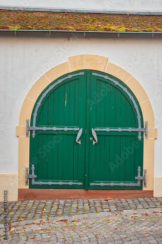Green door with fish handles on a building in the village of Florsheim Dalsheim, Germany. photo