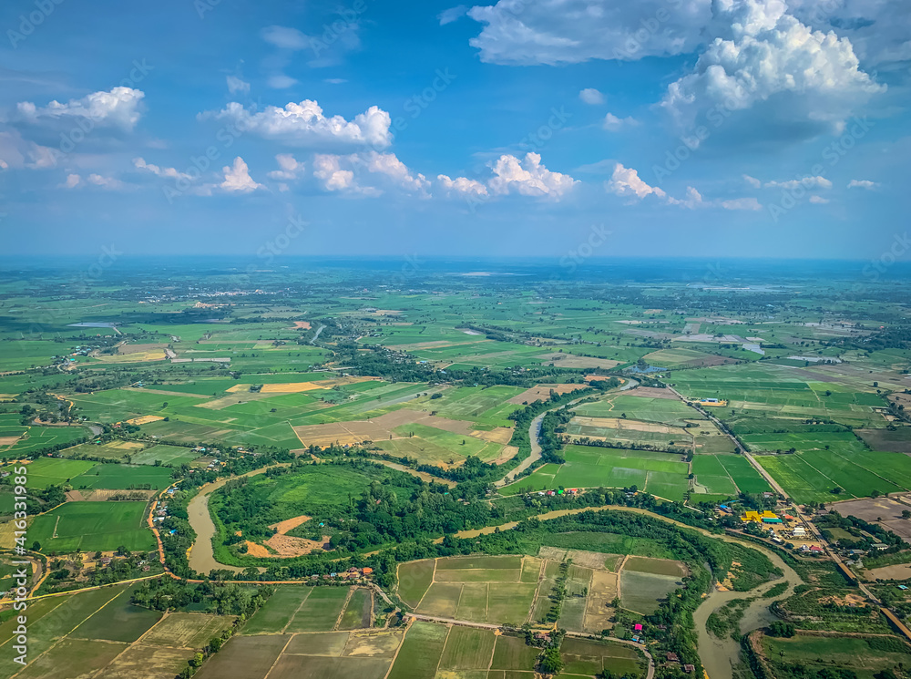 river cross green land with blue sky from aerial view