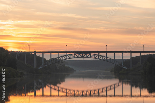 landscape of a railway bridge over the river during sunset