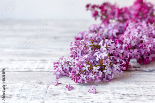 Purple lilac branch on table, floral still life on gray wooden background. Purple lilac Spring branches of blooming lilac festive bouquet of flowers with copy space