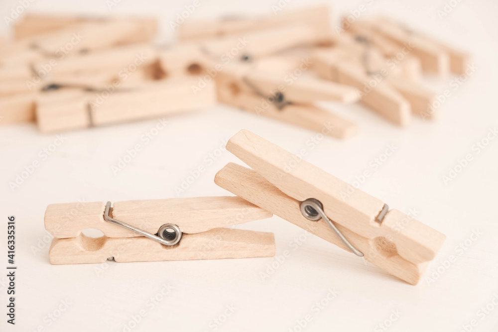 Many wooden clothespins on a white table background. Housework concept. Copy, empty space for text Many wooden clothespins on a white table background. Housework concept. Copy, empty space for text
