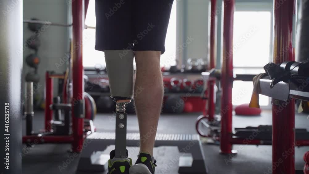 Man with prosthetic leg make pull ups at the gym Man with prosthetic leg make pull ups at the gym