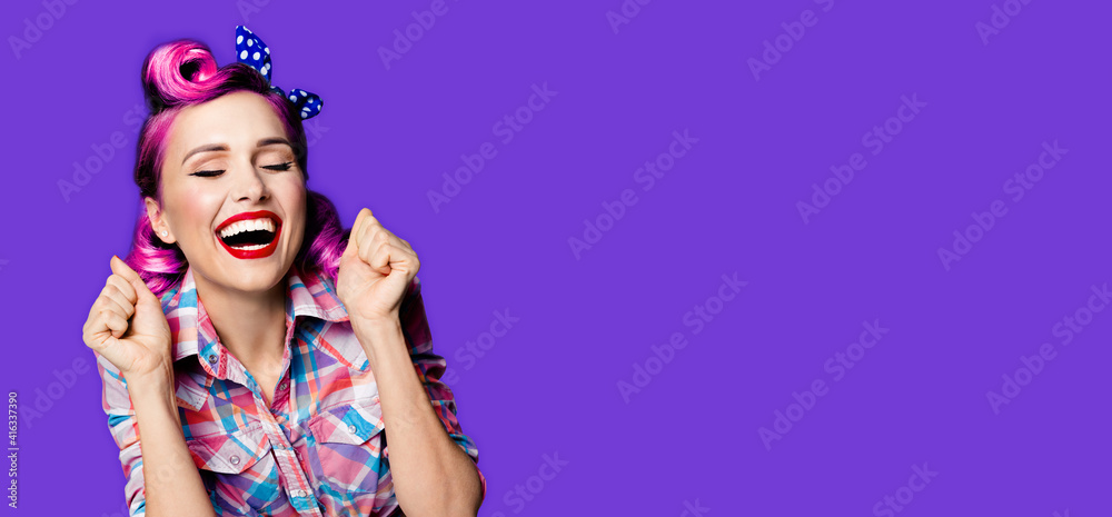 Fototapeta premium Unbelievable news! Excited surprised, very happy purple woman. Pin up girl with open mouth and closed eyes with raised hands. Retro and vintage concept. Violet color background. Wide composition image