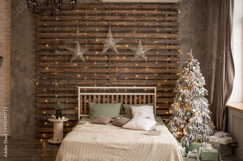 Bed with New Year's decorations. New Year's interior. Christmas tree.