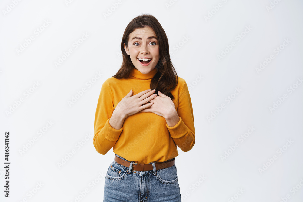 Wow is it for me. Surprised cute woman receive surprise gift, holding hands on heart, feeling touched and pleased, staring at camera excited, standing on white background Wow is it for me. Surprised cute woman receive surprise gift, holding hands on heart, feeling touched and pleased, staring at camera excited, standing on white background