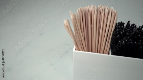 Slow motion angle top down view of beauty treatment products in a white container. White and grey marble background. Beauty salon concept footage.