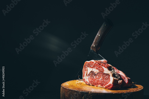 butcher knife and meat on a cutting board photo