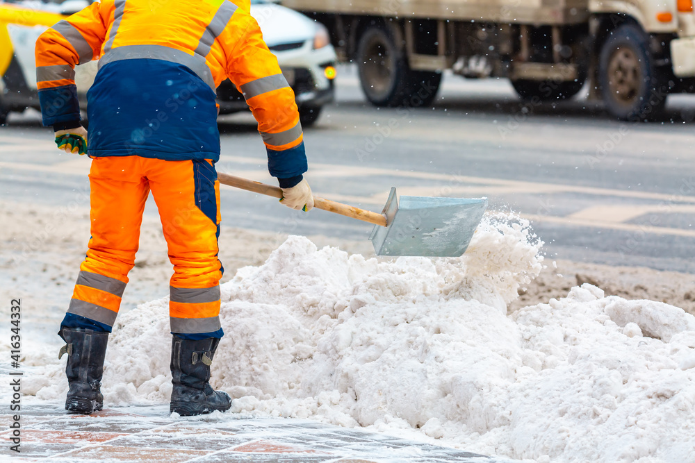 Communal services worker sweeps snow from road in winter, Cleaning city streets and roads during snowstorm. Moscow, Russia. Communal services worker sweeps snow from road in winter, Cleaning city streets and roads during snowstorm. Moscow, Russia.