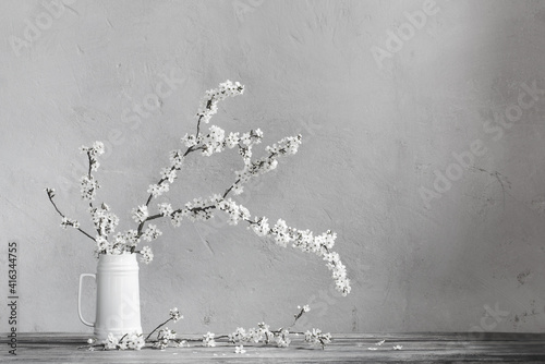 cherry flowers in white jug on old wooden table
