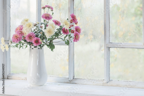 chrysanthemums in  vase on  windowsill in autumn © Maya Kruchancova