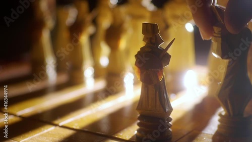 Hand moves Handmade chess pieces close up. Handmade wooden chess set. Soft focus photo