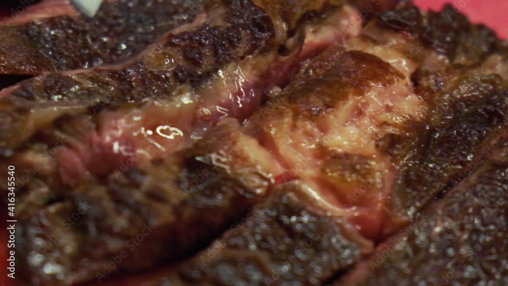 Chef is checking the meat with sharp knife. Tasty and juicy meat medium rare. Meat closeup on the professional kitchen. Chef is checking the meat with sharp knife. Tasty and juicy meat medium rare. Meat closeup on the professional kitchen.