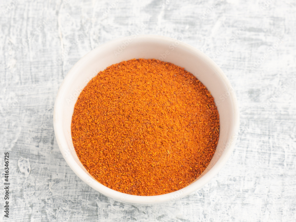 Spice red pepper chili in ceramic bowl on white concrete background Spice red pepper chili in ceramic bowl on white concrete background