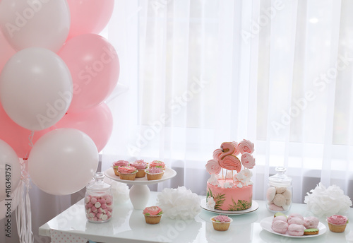 Pink cakes and pink balloons welcome guests to the party