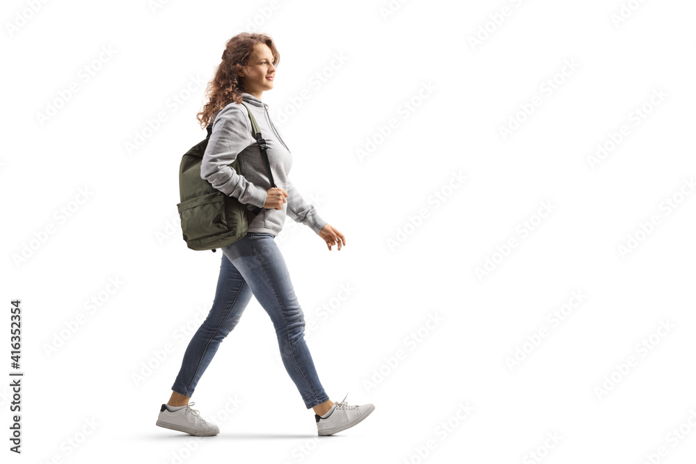 Full length profile shot of a female student in jeans with a backpack walking Full length profile shot of a female student in jeans with a backpack walking