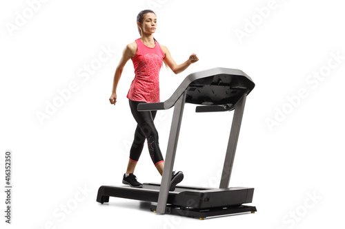 Full length shot of a serious young woman in sportswear walking on a treadmill