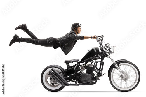 Young male biker riding a chopper and flying