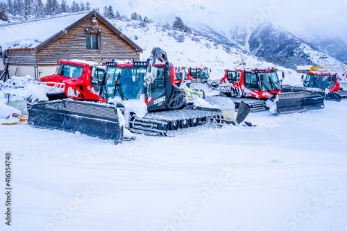 AURON, FRANCE - 02.01.2021: Snow plow trucks under the snow on a parking in the ski resort mountains. . High quality photo